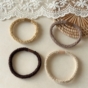 Detailed close-up of 4-pack elastic seamless hair ties in earth-toned knitted fabric