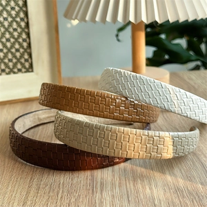 Elegant woven leather headband set in neutral tones for a high-volume hair look