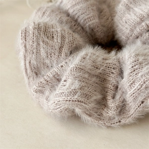 Gros plan sur le chouchou tricoté beige moelleux avec texture douce en fausse fourrure