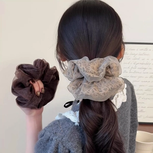Lot de chouchous en résille léopard et marron portés sur cheveux pour un effet volumineux