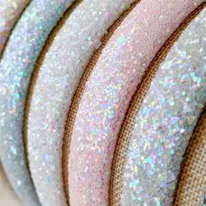 Macro detail of sparkling colorful sequins inside sheer mesh hairbands on linen base