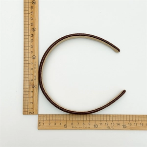Close-up of brown textured leather headband with crocodile pattern and internal soft lining