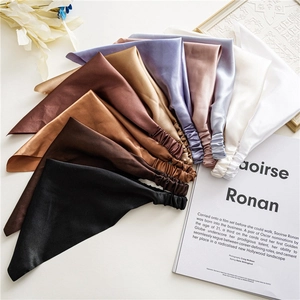 Close-up of assorted satin hair scarves with elastic bands in various elegant colors