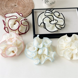 Detail view of large pleated organza hair scrunchies with contrast edges in five colors