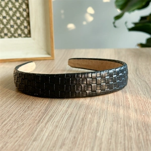 Close-up of black braided leather texture and non-slip lining on wide headband
