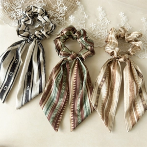 Three vintage satin scrunchies with long ribbons and diverse geometric patterns