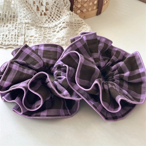 Close-up of purple and brown checkered plaid scrunchies with detailed stitched edges