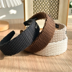 Thick knitted wide headbands in black, brown, and beige with handmade woven labels