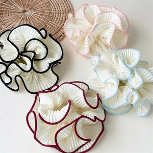 Detailed view of four elastic hair scrunchies with wavy edges and colorful piping detail