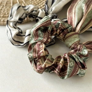 Close-up of bohemian style satin scrunchies with retro ethnic prints and stripes