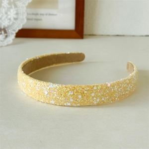 Close-up of yellow sequined headband with non-slip velvet lining and shimmering details