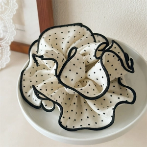 Polka dot oversized scrunchie with wood ear ruffle edge on a white ceramic plate