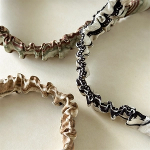 Detail shot of three elastic silk scrunchies with marble and geometric prints
