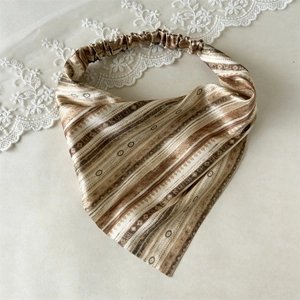 Flat lay of a bohemian silk-satin triangle hair scarf with retro striped patterns