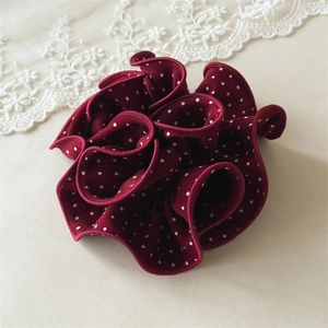 Close-up of wine red polka dot scrunchie with layered ruffle details and soft fabric texture