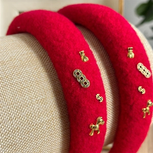 Makro-Detail von roten Samt-Haarbändern mit goldenen Pferde-Anhängern und Accessoires