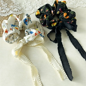 Detail of floral chiffon scrunchies with long ribbons and delicate ruffled edges