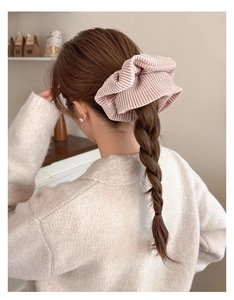 Chouchou en velours côtelé rose montrant la texture côtelée sur une tresse de modèle