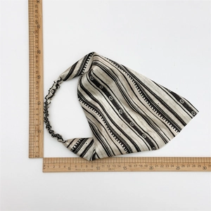 Detailed view of elastic striped knot headband with dimensions shown on a wooden ruler