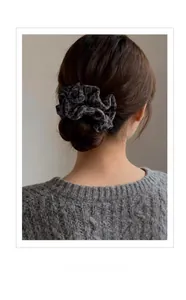 Gros plan d'un chouchou léopard en daim porté sur un chignon bas élégant pour femme