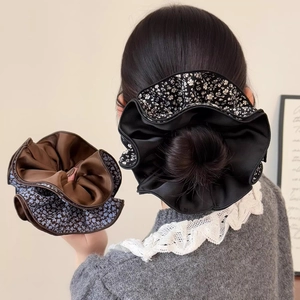 Detail of floral and satin layered scrunchies showing fabric texture and ruffles