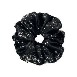 Glossy black fabric scrunchie with silver foil patterns on a clean white background