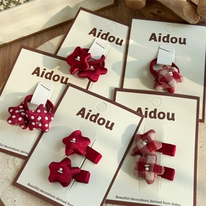Star-shaped red fabric hair ties and clips set with polka dots and pearls on card