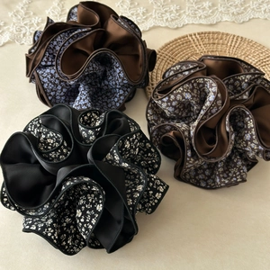Detail view of large floral scrunchies in vintage brown and black with layered pleats