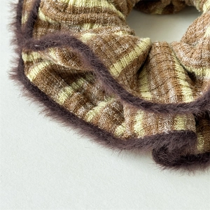 Detail of striped knit scrunchie with dark brown faux fur trim for winter hair styling