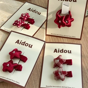 Detailed view of red fabric star hair accessories with pearls and polka dot patterns