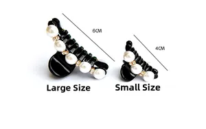 Detail view of black resin hair clips with white pearls and gold rhinestones in 4cm and 6cm sizes