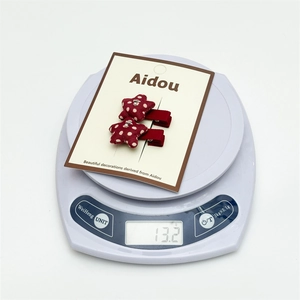 Detailed scale view of red polka dot star hair clips showing a total weight of 13.2g