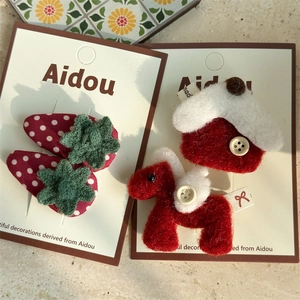 Détail de pinces à cheveux poney en feutre rouge et fraise avec accents tricotés pour femmes