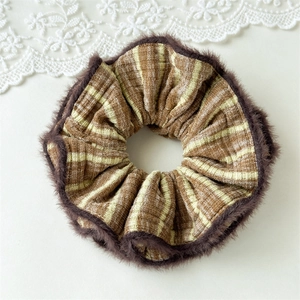 Detail of winter brown striped scrunchie with soft plush faux fur trim on white background