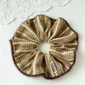 Detail of striped knitted scrunchie with plush trim and small white things label
