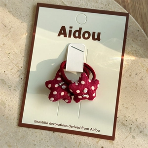 Detail of red polka dot star hair ties set on display card with pearl accents