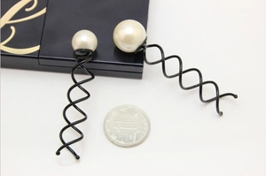 Détail d'épingles à cheveux spirale avec perles en deux tailles et pièce de mesure