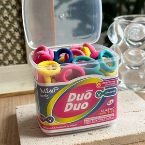 Detailed view of colorful elastic hair ties in a transparent box with MSMP kids branding