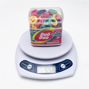 Colorful elastic hair ties for kids on a digital scale weighing fifty-five grams