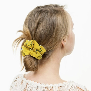 Floral chiffon scrunchie in yellow with blue patterns on a blonde bun hairstyle