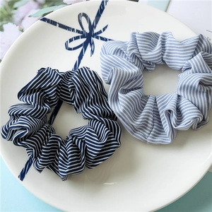 Detail of blue striped fabric scrunchies in a decorative porcelain dish with ribbon art