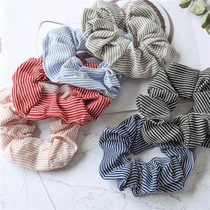 Set of 6 striped fabric hair scrunchies in various colors on a marble surface