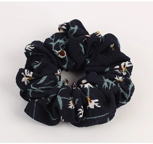 Detailed texture of navy blue floral chiffon hair scrunchie with daisy pattern print
