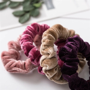 Primo piano di elastici per capelli in velluto rosa, fucsia, caffè e viola morbidi