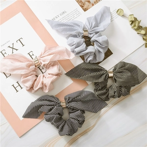 Close-up of striped chiffon rabbit ear scrunchies with elegant gold metal ring accents