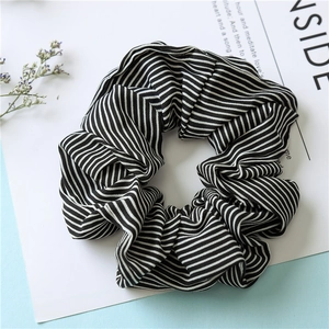 Detail shot of black and white striped fabric scrunchie with soft pleated texture