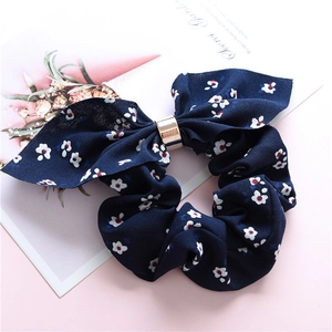 Detail of navy floral scrunchie with rabbit ear bow and golden metal buckle decoration
