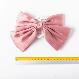 Detail view of 15cm pink chiffon bow hair clip with measurement scale reference