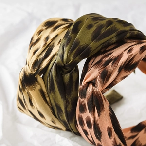 Detail view of leopard print satin headbands with twisted knot design in multiple colors