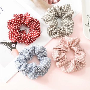 Détails de quatre chouchous en mousseline à pois en rouge, gris, bleu et rose clair